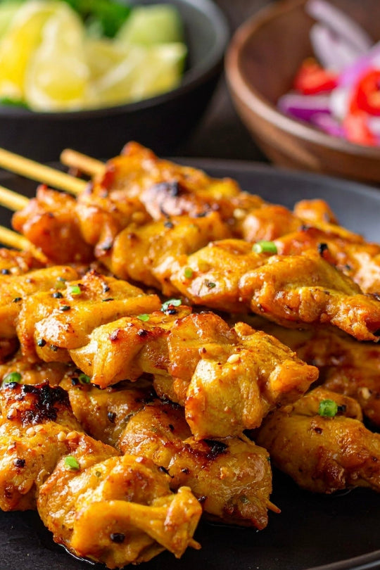 chicken skewers on wooden skewers with lime, ginger, garlic, peanuts.