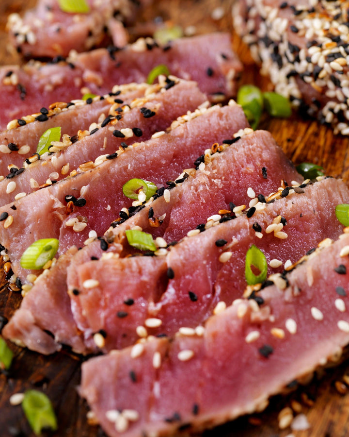 close up of sliced seared ahi tuna sprinkled with sesame seeds and scallions